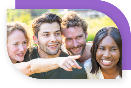 A group of young adults smile and share a moment as one of them points at something off camera.