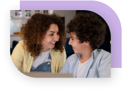 A child smiles while talking to an adult.