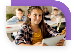 A girl using a tablet in school and smiling confidently.