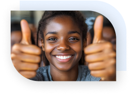 A young teen smiling and holding both hands up with a thumbs up signal.