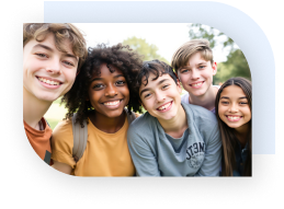 Five teens smiling and leaning in to take a selfie.