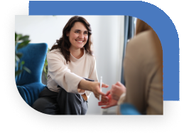 A therapists reaches toward a patient's hand.