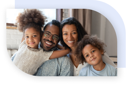A happy family with two girls sitting close together and smiling.